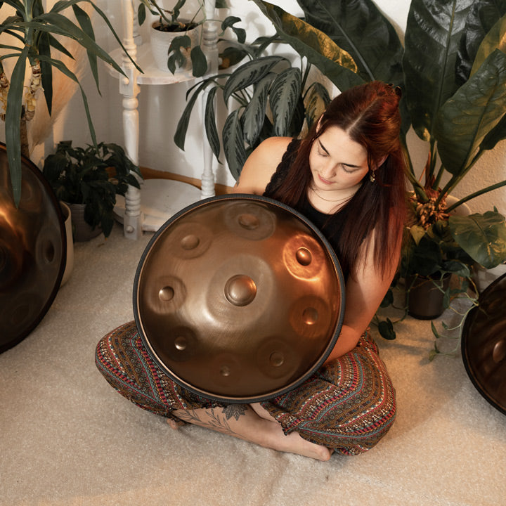 Handpanspielerin zeigt eine handgefertigte AeloPan Mini- Handpan aus Edelstahl. Diese und viele andere Handpans günstig bei Handpan.World Kaufen