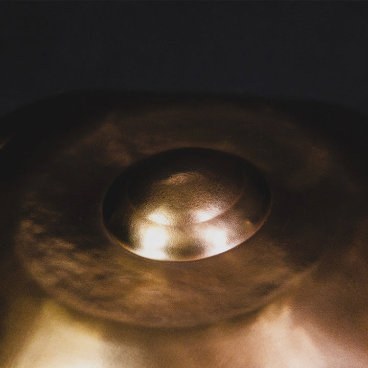 Nahaufnahme des Dings einer goldenen Handromeda Handpan. Handpan mit unterschiedlichen Tonfeldern und Skalen bei Handpan.World kaufen.