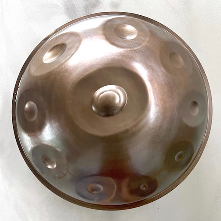 Bronze schimmernde perfekte Svaraa Handpan steht auf einem grauen Hintergrund. Sie ist schön belichtet und klingt wundervoll
