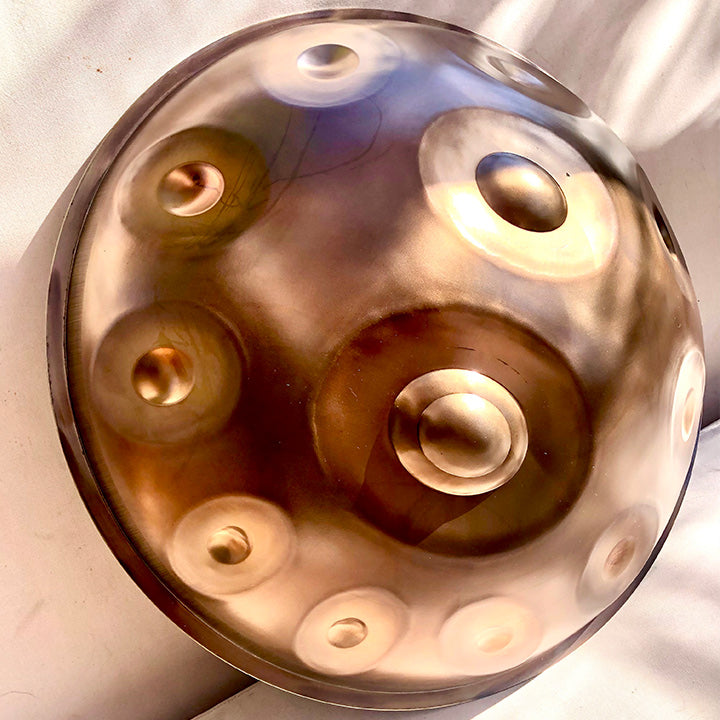 Eine NamiPan Handpan in Embersteel steht in der Sonne. Finde die zu dir passende Scale bei Handpan.World