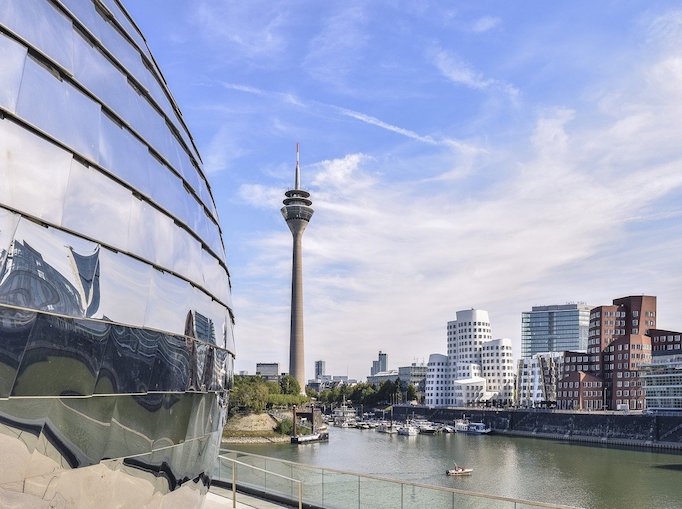 Der Rhein und der Rheinturm bei blauem Himmel durchzogen mit weißen Wolken