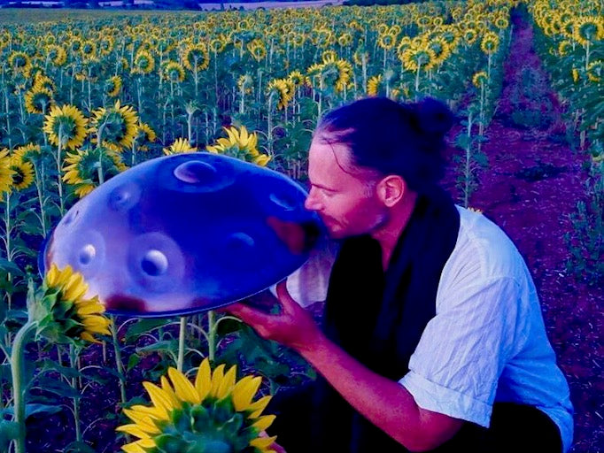 Handpan.world Vertreter Holger mit seiner Handpan in einem Sonnenblumenfeld.