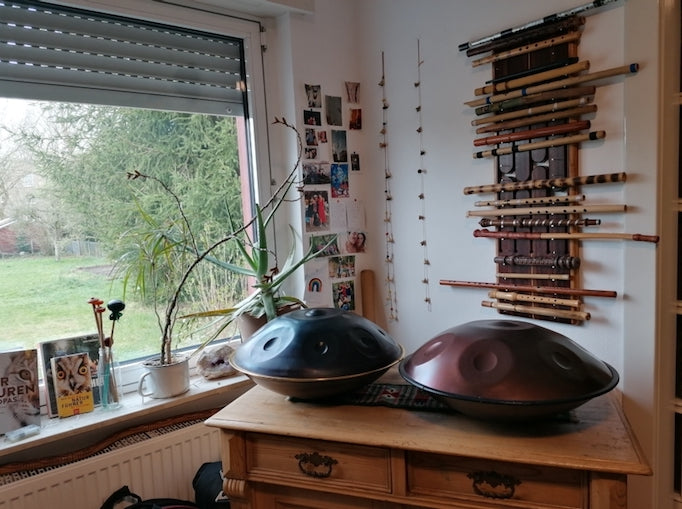 Eine nitrierte und eine Handpan aus Edelstahl stehen auf einem Holztisch im Handpan Showroom Bielefeld.