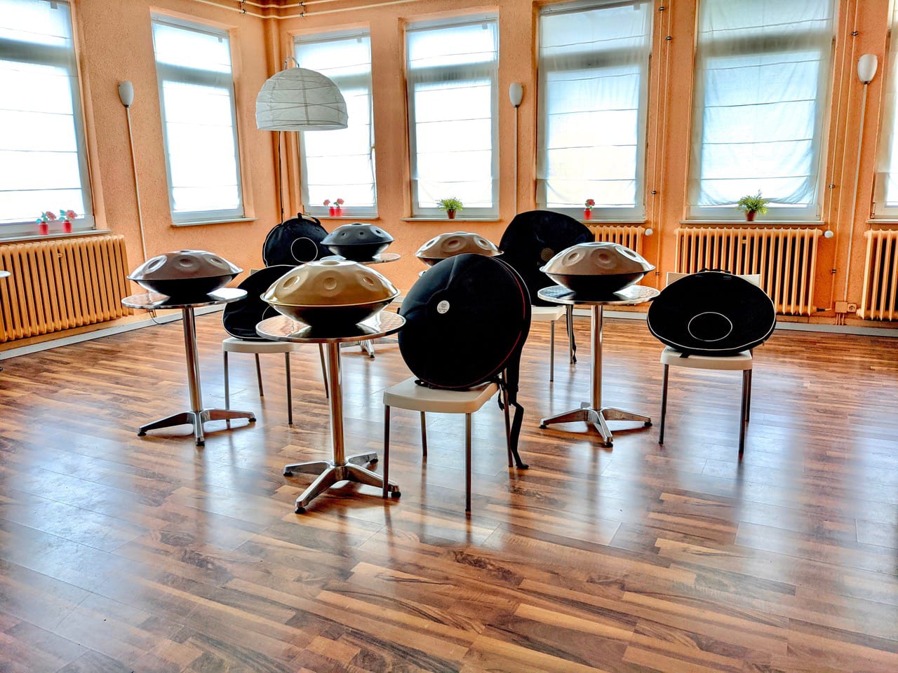 Mehrere edelstahl Handpans stehen auf kleinen runden Tischen im lichtdurchflutetem Ludwigstheather in Aschaffenburg