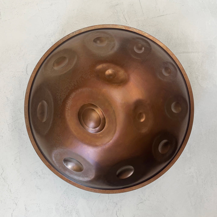 Vogelperspektive eine Nala Mutant Handpan aus Embersteel in der Stimmung D Kurd auf weißem Hintergrund. Tauche ein in die wundervolle Welt der Handpans und lass dich inspirieren.