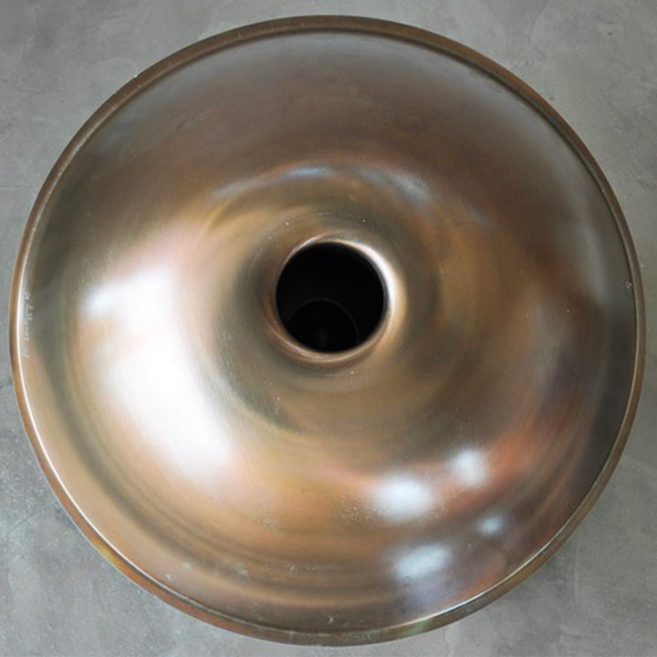 Unterseite einer Svaraa Handpan Drum ohne Bottomnotes mit einem perfekten Spiralmuster. Das Licht spiegelt sich schön in der Oberfläche