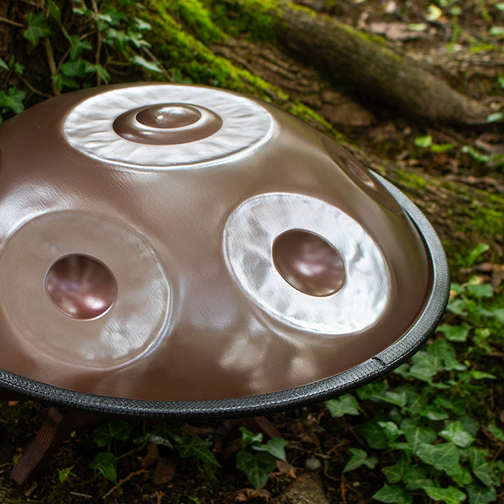 Mini Spirit Soul Handpan aus Edelstahl liegt zwischen Pflanzen und Bäumen in der Natur.