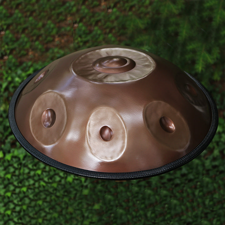 Mini Spirit Soul Handpan aus Edelstahl liegt zwischen Pflanzen und Bäumen in der Natur.