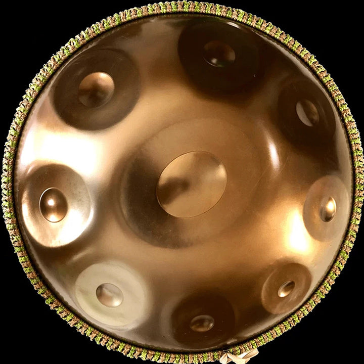 Goldene Edelstahl NamiPan von oben mit 9 Tonfeldern auf einem schwarzen Hintergrund.