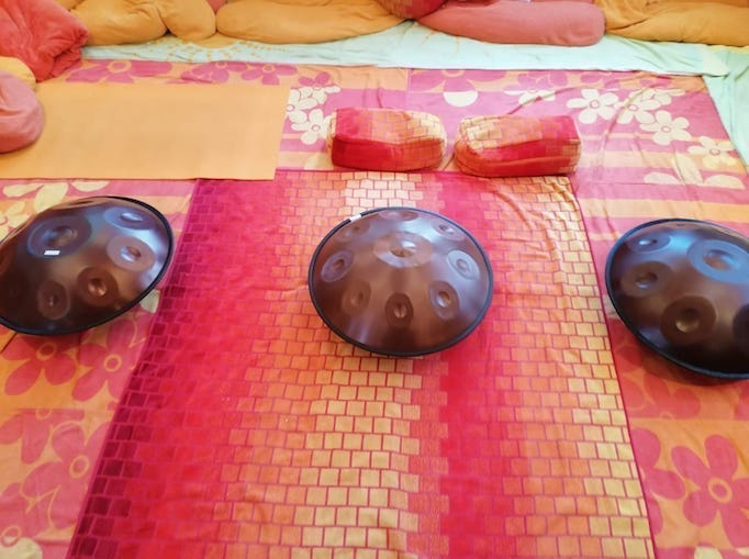 Drei Handpans liegen auf rot ornage gemusterten Tüchern auf dem Boden zum Probespielen im Showroom Wien