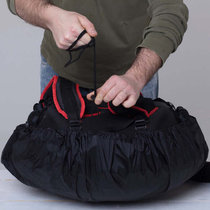 Mann fixiert Regenschutz auf Handpan Tasche