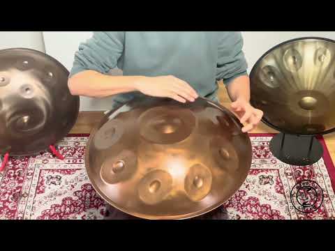 Ein Handpan-Spieler sitzt auf einem kunstvoll gestalteten Teppich, umgeben von Handpans, während er den schönen Klang des Lumar D Kurd Handpans demonstriert.