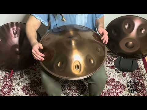 Ein Handpan-Spieler spielt einen wunderschön gearbeiteten Nala D Kurd Handpan, während er über einem kunstvoll verzierten Teppich sitzt. Das Licht schimmert auf dem Handpan, während sich der Raum mit Musik füllt.