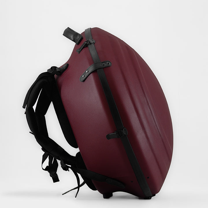 AVAYA Handpan Hardcase bequemer Rucksack gefertigt aus Fieberglaszum Besten Schutz deiner Handpan. Die Handpan Tasche hat einen schönen weinroten Kunstlederüberzug und steht auf einem schönen Holzwagen vor einer weißen Wand. Ansicht von der seite