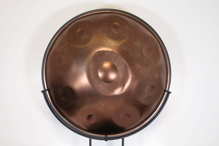 Bronzefarbene Handpan auf einem Ständer von vorne