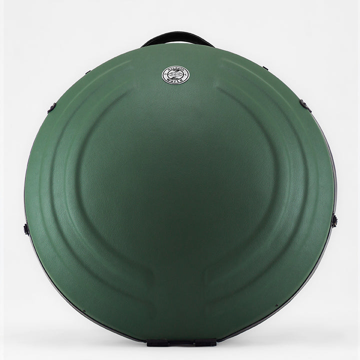 AVAYA Handpan Hardcase bequemer Rucksack gefertigt aus Fieberglaszum Besten Schutz deiner Handpan. Die Handpan Tasche hat einen schönen grünen Kunstlederüberzug und steht auf einem schönen Holzwagen vor einer weißen Wand.