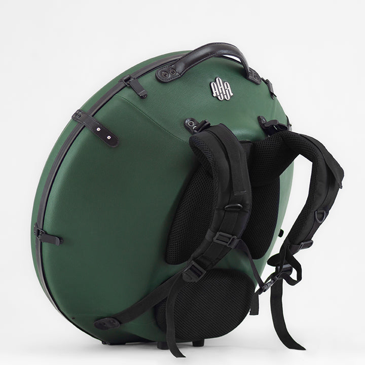 AVAYA Handpan Hardcase bequemer Rucksack gefertigt aus Fieberglaszum Besten Schutz deiner Handpan. Die Handpan Tasche hat einen schönen grünen Kunstlederüberzug und steht auf einem schönen Holzwagen vor einer weißen Wand. Ansicht von der Seite