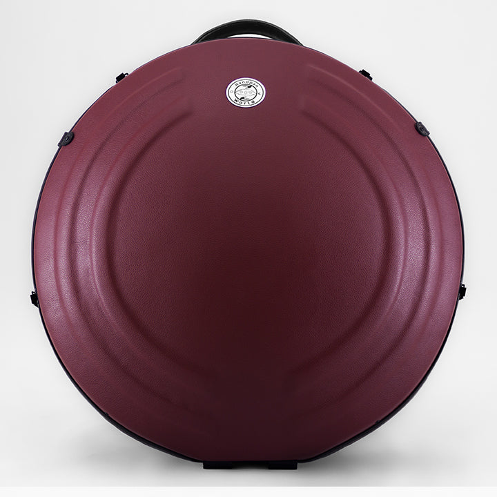 AVAYA Handpan Hardcase bequemer Rucksack gefertigt aus Fieberglaszum Besten Schutz deiner Handpan. Die Handpan Tasche hat einen schönen weinroten Kunstlederüberzug und steht auf einem schönen Holzwagen vor einer weißen Wand.