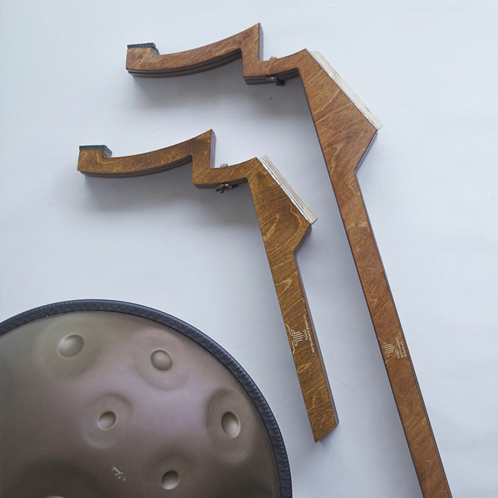 Zwei zusammengefaltete Katanui Handpan Drum Ständer aus Holz liegen nebeneinander auf einem weißen Hintergrund - Ein kleiner Handpanständer zum Spielen im Sitzen und ein großer zum Spielen von Handpans im Stehen.