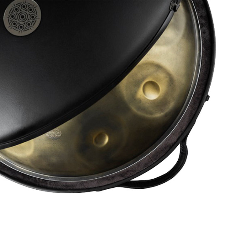 Leicht geöffnetes Handpan Hardcase im Black Classic Design, in dem eine Gold Vintage Kita Handpan liegt. Ein goldener Ausschnitt des Instruments ist zu sehen. 
