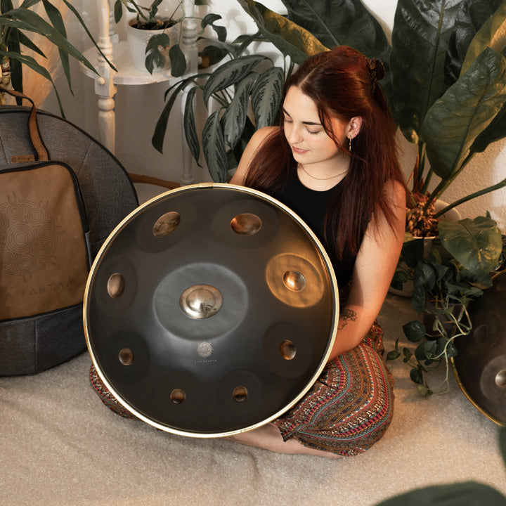 Handpanspielerin zeigt eine handgefertigte KitaPantam Handpan in dem Design Polished Gold. Diese und viele andere Handpans günstig bei Handpan.World Kaufen