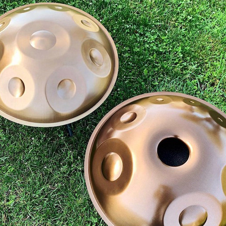 Zwei Extended Handpans gefertigt aus Titan Steel liegen im Gras. Eine Handpan die Ideal für Fortgeschrittene ist welche ihr Klangspiel erweitern möchten.