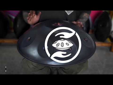 Vesierter Handpan Spieler spielt auf einer F#3 Hijaz Kita Pantam Handpan mit neun Tonfeldern im polished violet design.