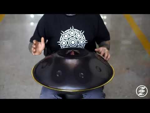 Ein bärtiger Handpanspieler mit Brille spielt sitzend auf einer nitrierten B2 Celtic Minor Kita Handpan.