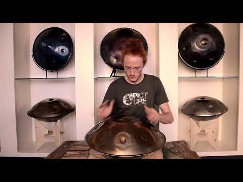 Rothaariger Handpanspieler spielt auf einer NamiPan C# Kurd. um ihn herum stehen 5 weitere Handpans.