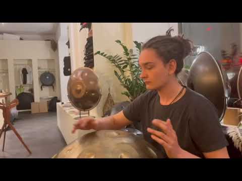 Handpanspieler mit Dreadlocks spielt im Handpan-Showroom München eine Kita Pantam C# Pygmy 15 nitriert im Gold-VintageLook