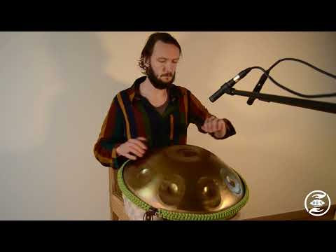 Bärtiger braunhaariger Handpanspieler spielt eine NamiPan Handpan / Pantam D Kurd 9 aus Embersteel